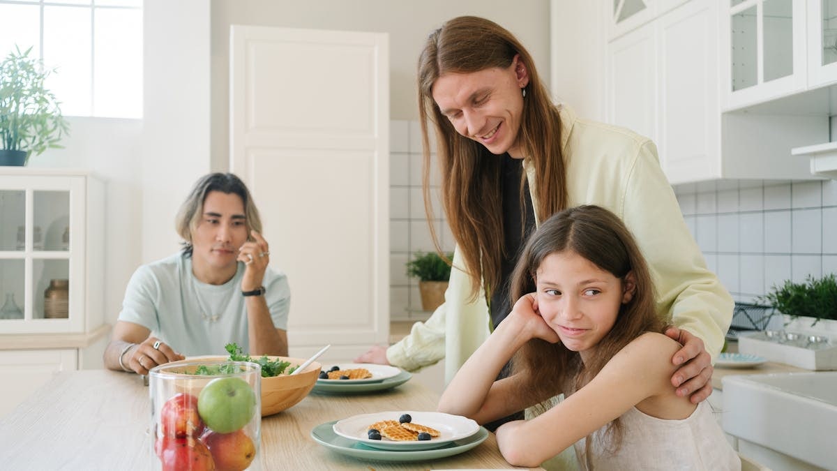 A family enjoys breakfast together in a bright, modern kitchen setting.